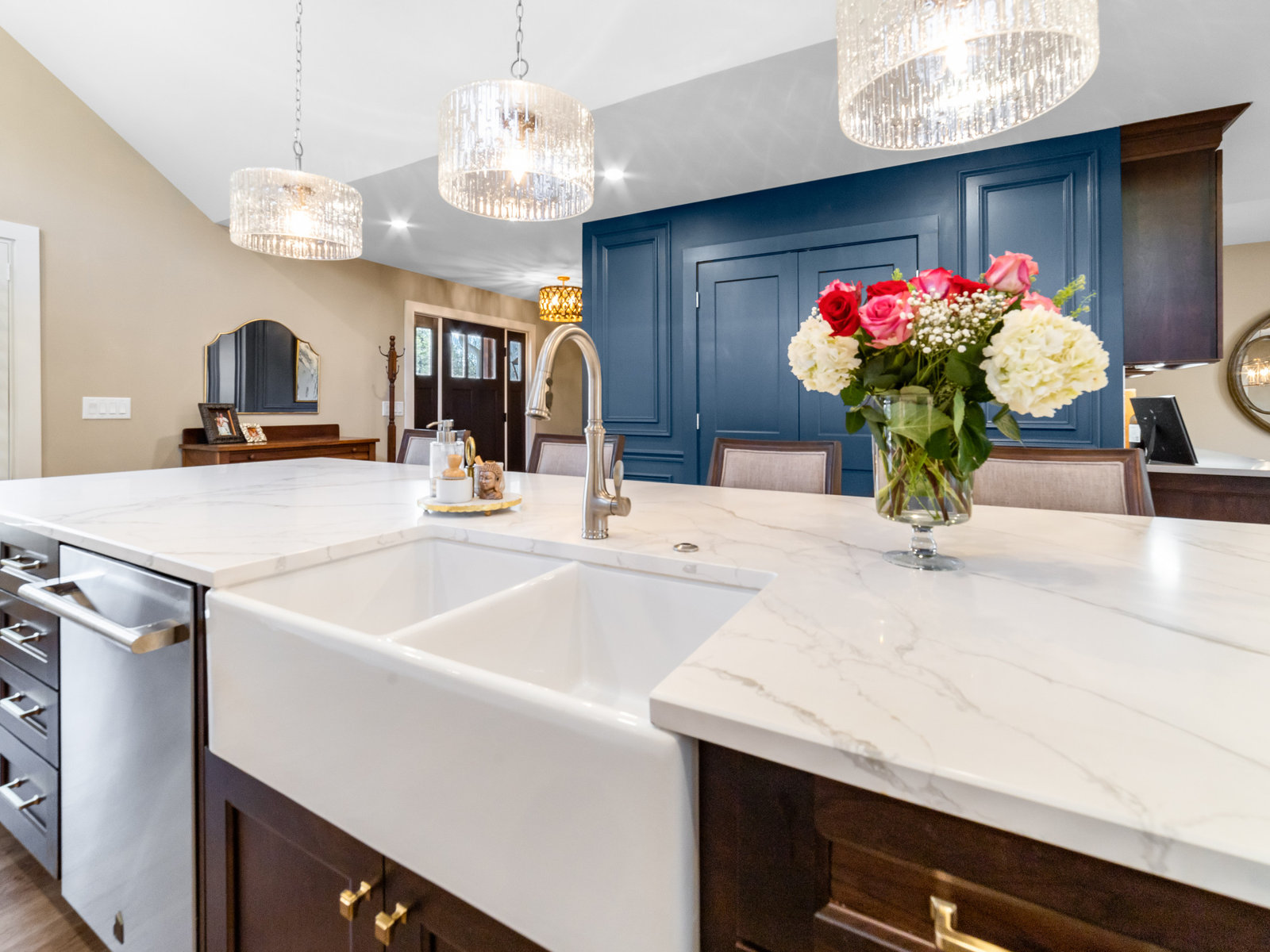 Custom kitchen remodel with navy island, marble countertops and brass hardware